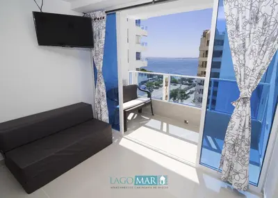 a room with a balcony with a view of the ocean at Marea Laguito Apartamentos Cartagena in Cartagena de Indias