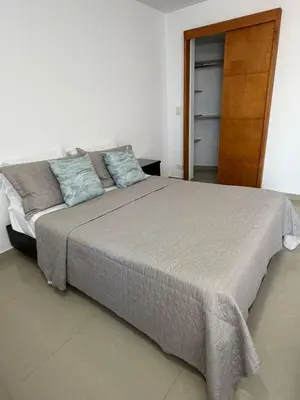 a bedroom with a large bed with blue pillows at Lujoso Apartamento en Cartagena in Cartagena de Indias