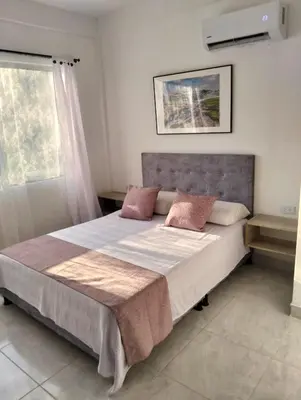 a bedroom with a large bed with pink pillows at Sandymar in San Bernardo del Viento