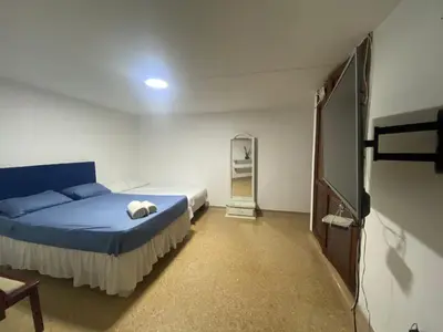 a bedroom with a blue bed and a mirror at Refugio Cartagena Kawica Bocagrande in Cartagena de Indias
