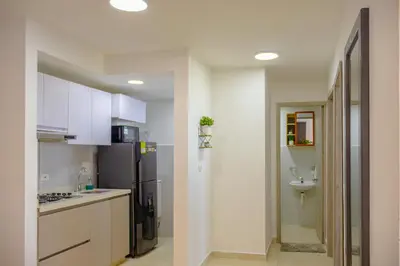 a kitchen with white cabinets and a black refrigerator at View 17, Modern, 5 min from Rafael Nuñez Airport in Cartagena de Indias