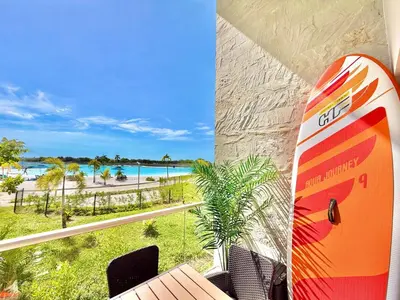 a surfboard sitting on a balcony with a view of a beach at kristal lagoon view apartement in Cartagena de Indias