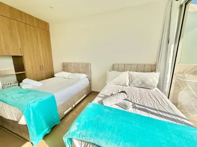 two beds in a small room with blue sheets at kristal lagoon view apartement in Cartagena de Indias