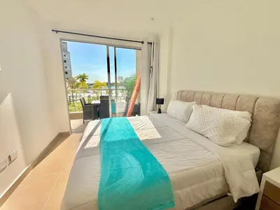 a bedroom with a bed with a view of a balcony at kristal lagoon view apartement in Cartagena de Indias