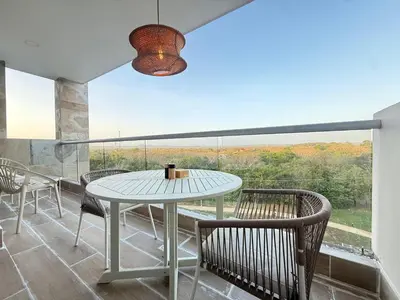 a dining room with a table and chairs and a large window at Suite Exclusiva Baia Kristal, Zona Kabo 3 in Cartagena de Indias