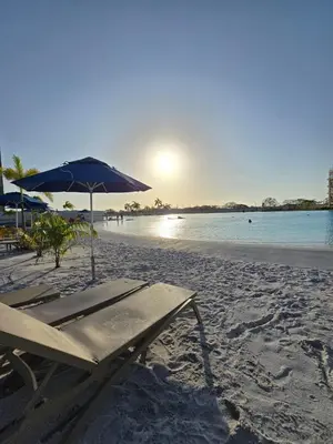 a beach with an umbrella and chairs on the sand at Suite Exclusiva Baia Kristal, Zona Kabo 3 in Cartagena de Indias