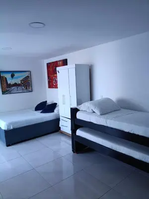 a bedroom with two beds and a cabinet in it at Estudio piso 9 APTO 909 in Cartagena de Indias