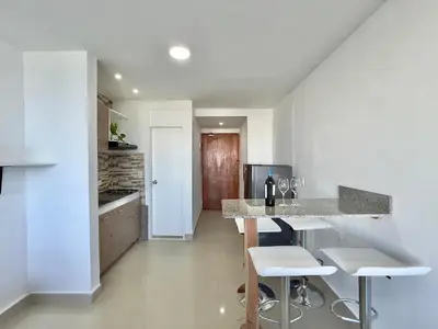 a kitchen with a bar with stools and a counter at Riviera Mulata Loft - Apartamento con vista al mar in Cartagena de Indias