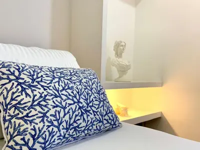 a bed with a blue and white pillow on it at Amoblados Cartagena, El Laguito in Cartagena de Indias