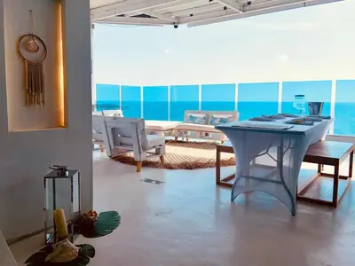 a living room with a table and a view of the ocean at Amoblados Cartagena, El Laguito in Cartagena de Indias