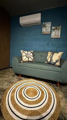 a living room with a green couch and a rug at Cabaña la Industrial in Coveñas
