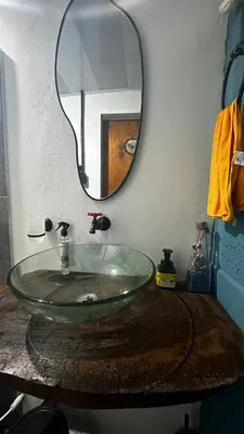 a bathroom with a glass sink and a mirror at Cabaña la Industrial in Coveñas