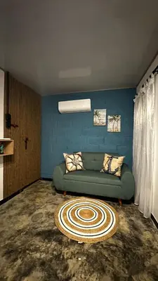 a living room with a green couch and a blue wall at Cabaña la Industrial in Coveñas