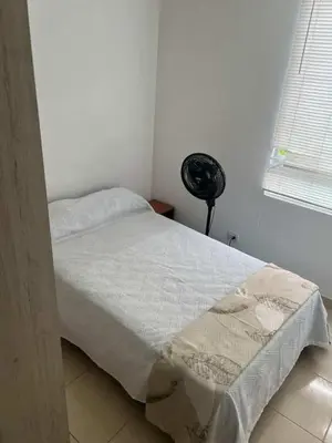 a bedroom with a bed with a white sheets and a window at Modern and renowned apartment in Cartagena in Cartagena de Indias