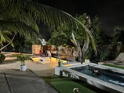 a couple of people in a pool in a yard at House Las Palmas villa privada in Puerto Colombia