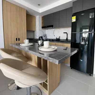 a kitchen with a counter and a black refrigerator at Despierta con vista al mar en el corazón de CTG in Cartagena de Indias