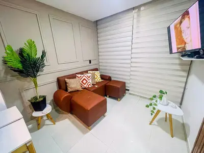 a living room with a brown couch and a plant at Business Stay More30Days Fast WiFi Premium Comfort in Cartagena de Indias