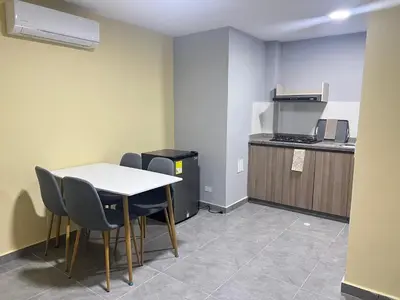 a room with a table and chairs and a kitchen at Nora la bella in Barranquilla