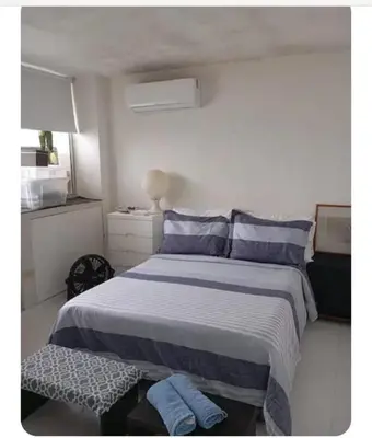 a bedroom with a large bed with blue pillows at APARTAESTUDIO Con Espectacular Vista in Cartagena de Indias