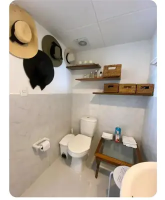 a bathroom with a toilet and a table and a hat at APARTAESTUDIO Con Espectacular Vista in Cartagena de Indias