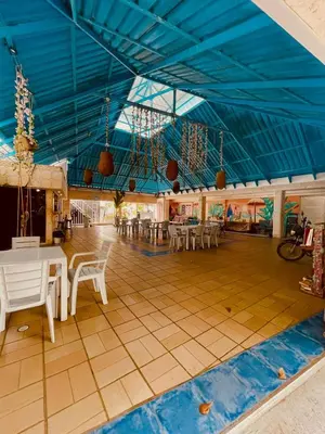 a large room with tables and chairs and a blue ceiling at Wonderland Cartagena in Cartagena de Indias