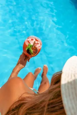 a woman laying in a swimming pool holding a fruit at Wonderland Cartagena in Cartagena de Indias