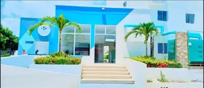 a blue building with palm trees in front of it at Apartamento en Torices Piso 24 - Cartagena - Playa cerca al Mar in Cartagena de Indias