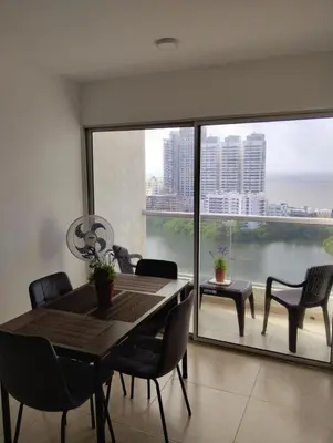 a dining room with a table and chairs and a large window at New Apartment Frente al Mar, Cerca Getsemani in Cartagena de Indias