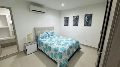 a bedroom with a bed with a blue comforter at Lindo & Cómodo Apartamento en La boquilla in Cartagena de Indias