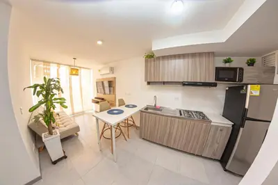 a small kitchen with a table and a refrigerator at Apartamento cerca al Mar y a el Centro Histórico in Cartagena de Indias