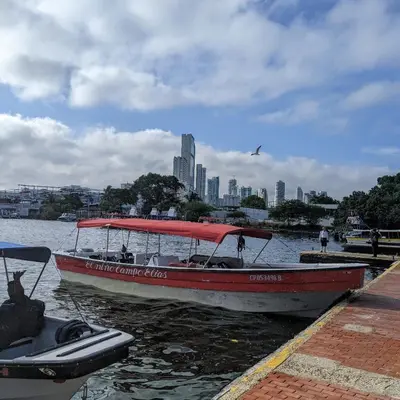 a boat is docked in the water near a city at Eco Hotel Islabela Deluxe in Isla Grande