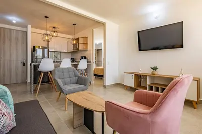 a living room with a table and chairs and a television at MarNilo House Serena del Mar Cartagena in Cartagena de Indias
