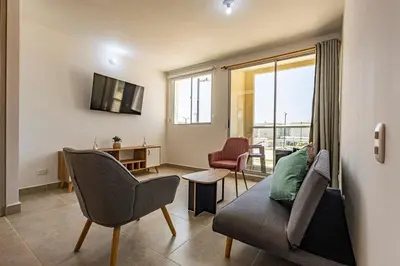 a living room with a couch and chairs and a window at MarNilo House Serena del Mar Cartagena in Cartagena de Indias