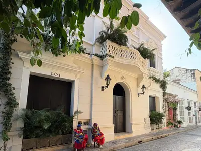 two girls in traditional dress standing outside of a building at Casa De La Imprenta in Cartagena de Indias