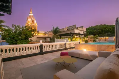 a rooftop patio with a view of a clock tower at Casa De La Imprenta in Cartagena de Indias