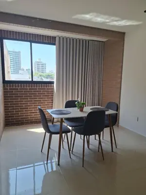 a dining room with two tables and chairs and a window at Edificio Shanty- Easy Rents Sas in Barranquilla