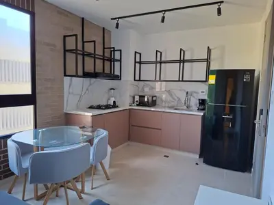a kitchen with a glass table and a black refrigerator at Edificio Shanty- Easy Rents Sas in Barranquilla