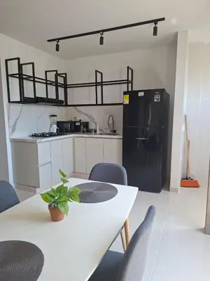 a kitchen with a white table and a black refrigerator at Edificio Shanty- Easy Rents Sas in Barranquilla