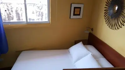 a bedroom with a bed with white sheets and a window at Apto exclusivo Centro Historico in Cartagena de Indias