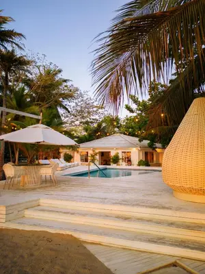 a resort with a swimming pool and a palm tree at Quinta del Mar El Paraiso in Tolú