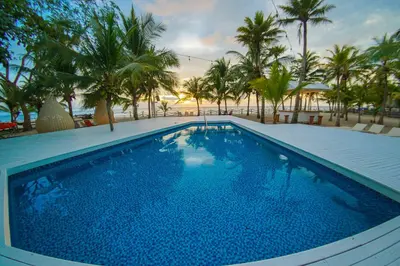 a large swimming pool with palm trees in the background at Quinta del Mar El Paraiso in Tolú