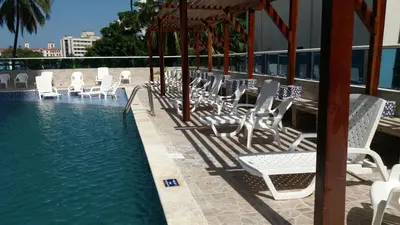 a group of white chairs sitting next to a swimming pool at Apartamento Boutique Cartagena in Cartagena de Indias
