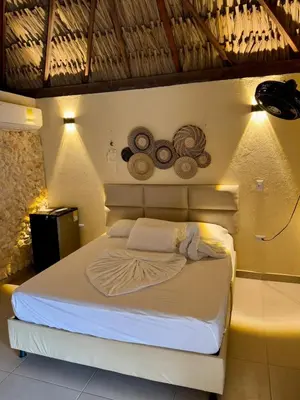 a bedroom with a white bed with lights on it at Awa de Mar Playa in Tolú