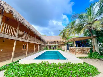 a villa with a swimming pool and a house at Awa de Mar Playa in Tolú