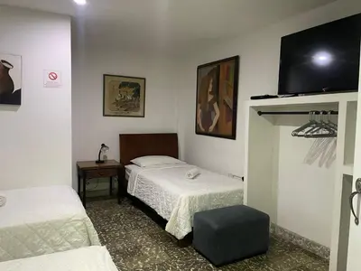 a room with two beds and a flat screen tv at Hotel Fegali Art Boutique in Cartagena de Indias