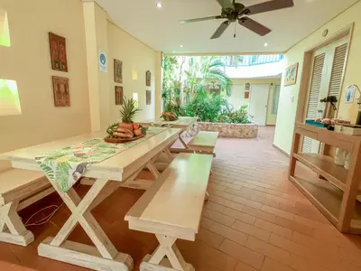 a dining room with a table and benches at Posada La Fe in Cartagena de Indias