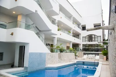 an exterior view of a building with a swimming pool at Hotel Dorado BAQ in Barranquilla