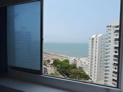 a window with a view of a beach and buildings at Apartamento Laguito Bocagrande in Cartagena de Indias