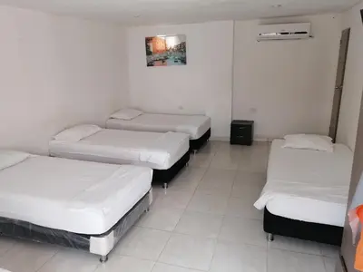 three beds in a room with white walls at Manzanillo Beach in Cartagena de Indias