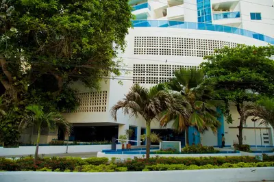 a building with palm trees in front of it at Apartamento Vista Mar 1707 in Cartagena de Indias